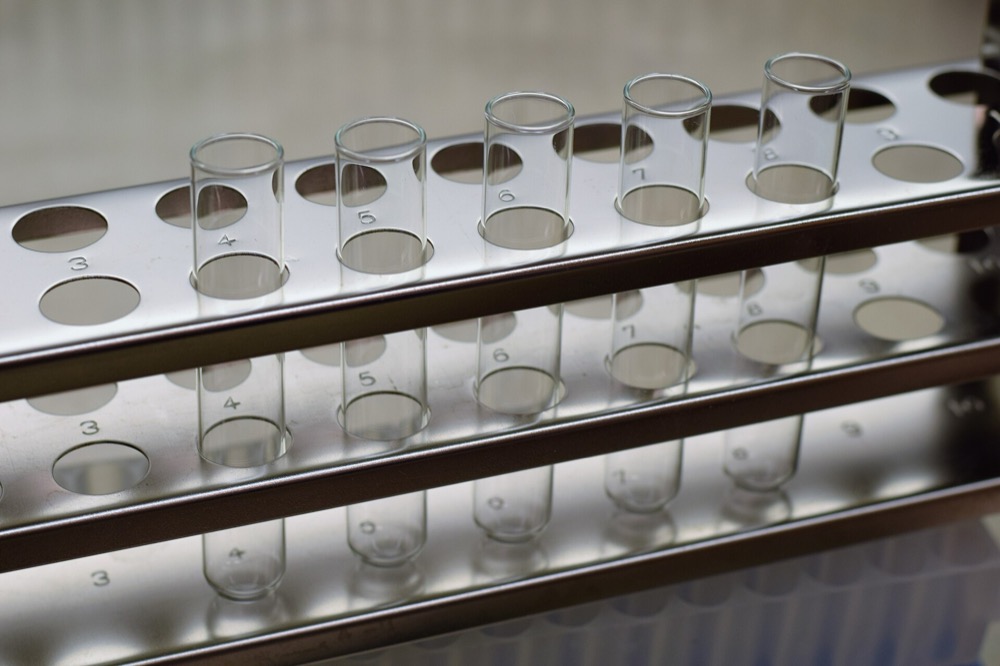 Empty glass test tubes standing in a steel rack